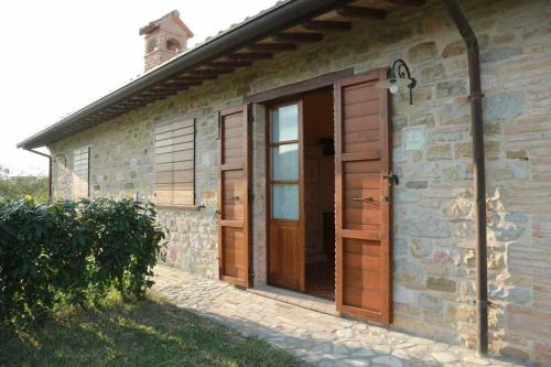 a brick building with a wooden door and a window at Agriturismo Colle Mura in Morano Madonnuccia