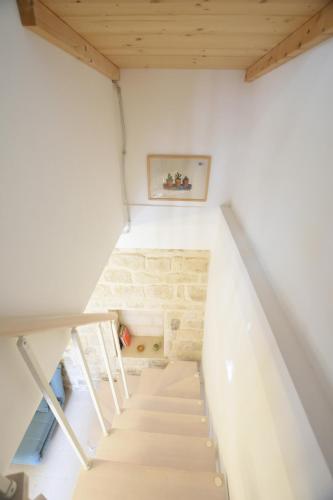 a staircase in a house with white walls and wooden ceilings at Casina Panta Rhei in Scicli