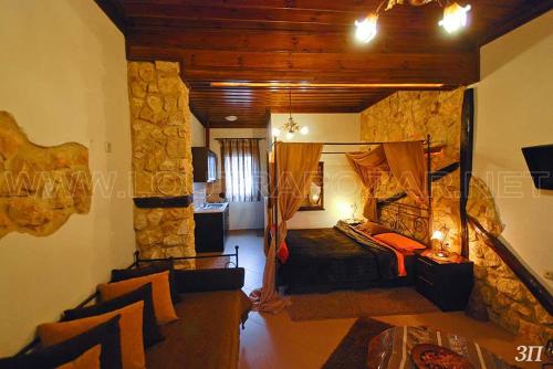 ein Wohnzimmer mit einem Zimmer mit einer Steinmauer in der Unterkunft Pansion Anastasia in Kato Loutraki