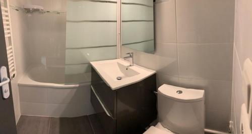 une salle de bain blanche avec un lavabo et des toilettes dans l'établissement Cosy T1 avec mezzanine, à 7' à pied de la plage et du centre, wifi, clim, parking privé, piscines, à Canet