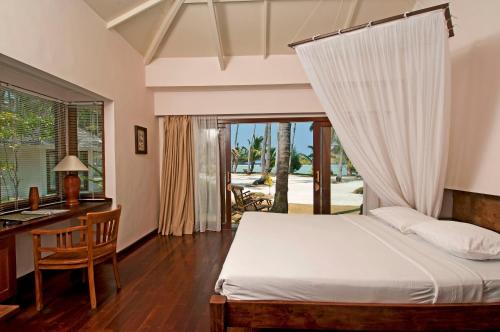 1 dormitorio con cama, escritorio y ventana en Kura Kura Resort en Karimunjawa
