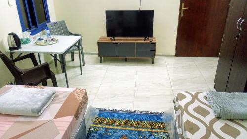 a living room with a tv and a table at SALEM House Hostel Nizwa in Nizwa