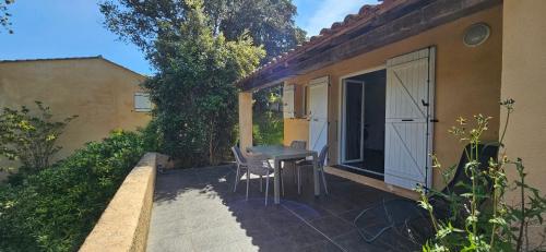 un patio avec une table et des chaises à côté d'un bâtiment dans l'établissement T2 Dolce & Vita C3 vue mer et piscine, à Propriano