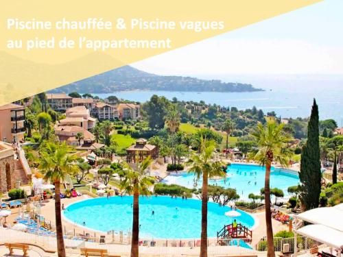 une vue d'une piscine dans un complexe hôtelier avec des palmiers dans l'établissement Cap Estérel Magnifique vue mer avec parking et piscine, à Saint-Raphaël