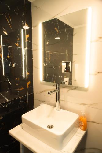 a bathroom with a white sink and a mirror at Aktis Sea View Studios in Perea