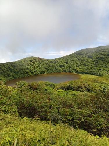 a small lake in the middle of a mountain at Cabaña el ojoche in Balgue