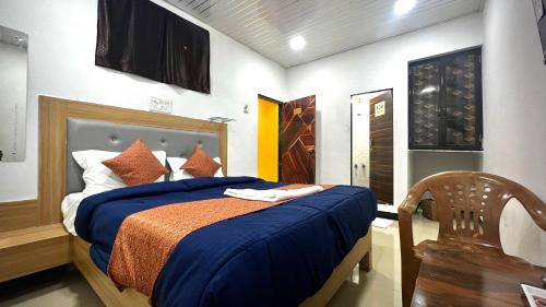 a bedroom with a bed with blue sheets and a chair at Hotel jazz & Cabin stay in Mumbai