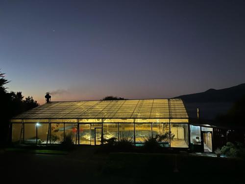 a large glass house with lights on it at night at Cabañas & Piscina Rucamalen in Ensenada