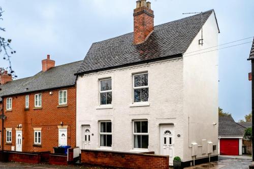a white house with a black roof at #34 Two bed apt Private Parking Stylish & homely - Near Tamworth Castle - Sleeps 5 -"Perfect for Contractors and Families" - Free Parking in Fazeley