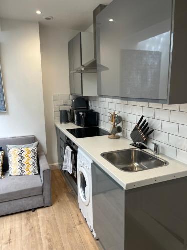 a kitchen with a sink and a washing machine at Gorgeous little gem in London