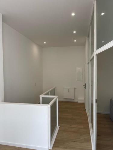 a hallway with white walls and a stair case at Maisonette drei Jahreszeiten in Norderney