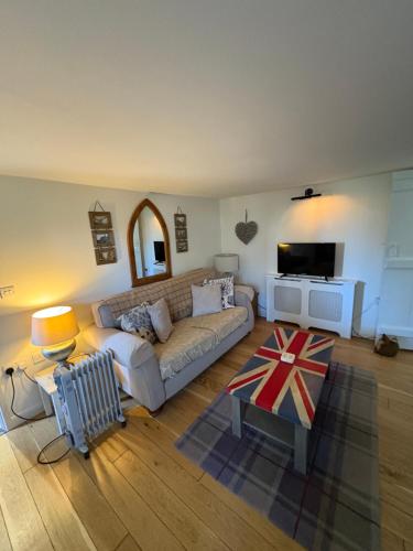 ein Wohnzimmer mit Sofa und Fernseher in der Unterkunft Old church cottage in Chulmleigh