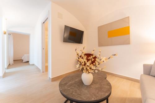 a living room with a vase of flowers on a table at Apartamentos Turísticos Zibá in Merida