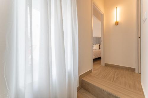 a white curtain in a hallway with a bedroom at Apartamentos Turísticos Zibá in Merida