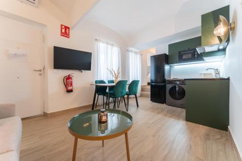 a living room with a table and chairs in a room at Apartamentos Turísticos Zibá in Merida
