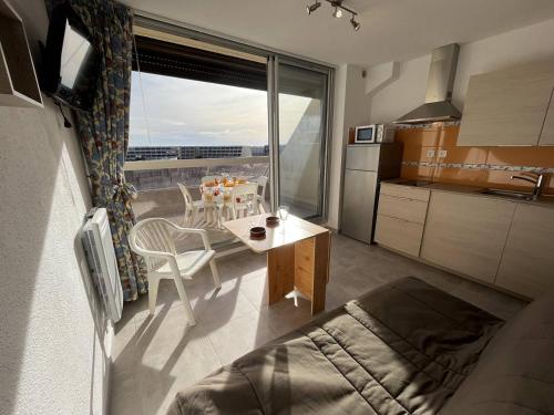 une cuisine avec une table et une salle à manger avec vue dans l'établissement Studio 2 couchages CAP D'AGDE NATURISME CN060-L10, au Cap d'Agde