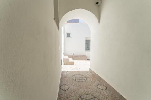 a hallway with an archway and a tile floor at Apartamentos Turísticos Zibá in Merida