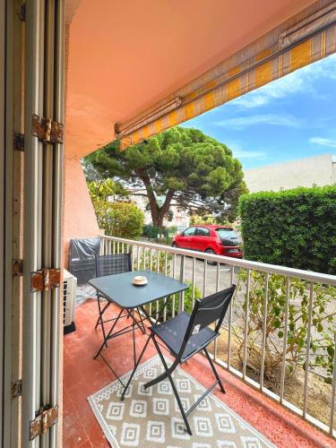 a patio with a table and a chair on a balcony at Appartement bohème-chic in Hyères