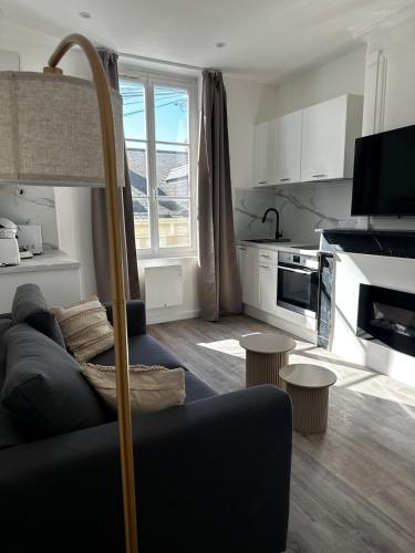 un salon avec un canapé et une cuisine dans l'établissement Les Jasmins - Centre Ville de Saumur, à Saumur