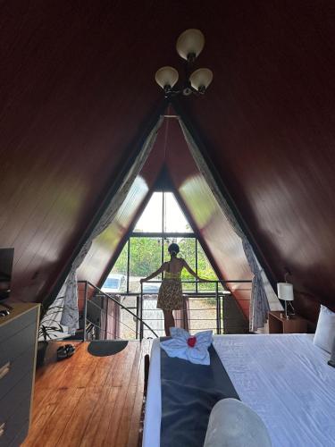 a woman standing inside of a triangle shaped tent at Yarumo Lodge, Río Celeste Black Chalets in Bijagua