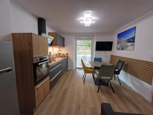une cuisine et une salle à manger avec une table et des chaises dans l'établissement Agréable 3 pièces au Lac Blanc, à Orbey