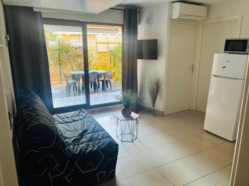 un salon avec un canapé et une table dans l'établissement Studio cabine en front de mer, à Fréjus