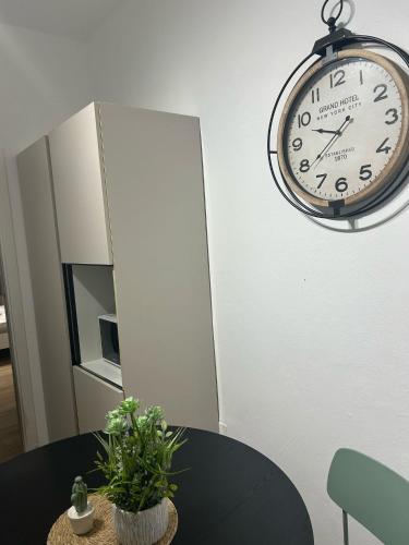 a clock hanging on a wall above a table at La dimora degli scrittori in Porto Empedocle