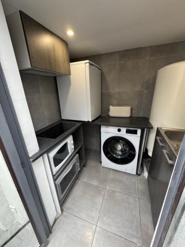 une petite cuisine avec un lave-linge et un lave-linge dans l'établissement Appartement Jardin 10mn centre, à Nice