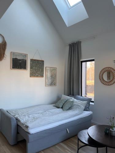 a bedroom with a bed in a room with a window at Nybyggd gästlägenhet med sovloft in Falkenberg