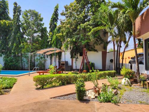 un giardino con piscina e una casa di Blandine's Little Heaven a Lomé