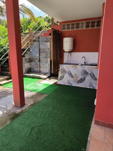 a room with a green floor in a house at studio Caraïbes in Les Trois-Îlets