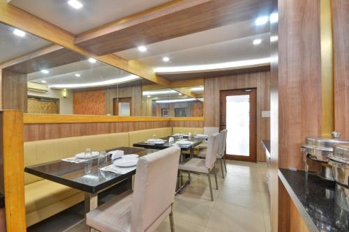 a dining room with tables and chairs in a restaurant at Townhouse Coastal Grand Hotels and Resorts in Coimbatore