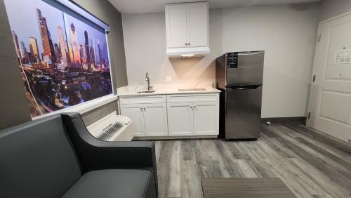 a kitchen with white cabinets and a refrigerator at Hotel Park Place in Houston