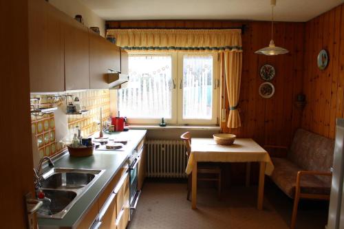 a kitchen with a sink and a table and a window at Elsa's Waldnest-Nähe Fichtelsee in Warmensteinach