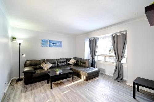 a living room with a leather couch and a table at 2 Bedroom Home In A Prime Location in Winnipeg