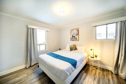 a bedroom with a bed and two windows at 2 Bedroom Home In A Prime Location in Winnipeg