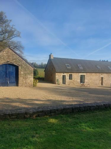 a stone barn with a blue door in a field at KERFERNAND in Berné
