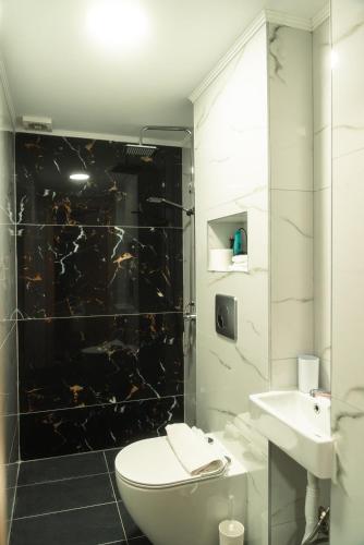 a bathroom with a toilet and a sink and a shower at Aktis Sea View Studios in Perea