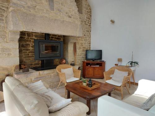 a living room with a couch and a fireplace at KERFERNAND in Berné