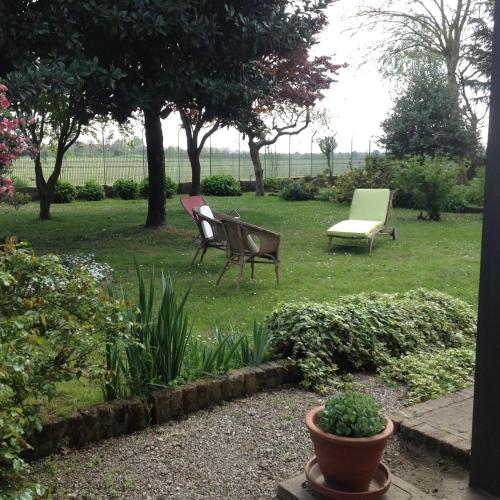 two chairs and a bench in a garden at Agriturismo La Morosina in Abbiategrasso