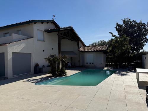une piscine devant une maison dans l'établissement VILLA piscine au GOLF, à Baillargues