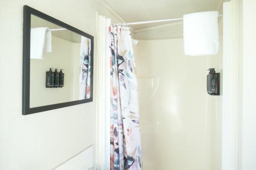a mirror in a bathroom next to a door at Riverside Whakatane Holiday Park in Whakatane