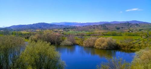 an aerial view of a river with trees and mountains at Orion Guesthouse Telhado in Fundão