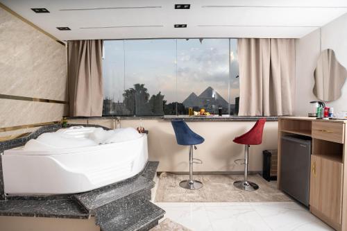 a bathroom with a tub and two stools at Quantum Pyramids View INN in Cairo