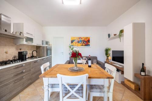 a kitchen with a wooden table and white chairs at Villino alla Colonna in Monteriggioni