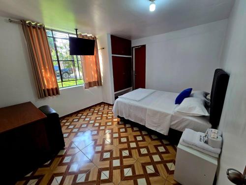 a bedroom with a bed and a television in it at Los Angeles Hotel in Huaral