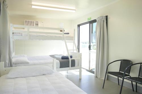 a bedroom with two bunk beds and a balcony at Riverside Whakatane Holiday Park in Whakatane