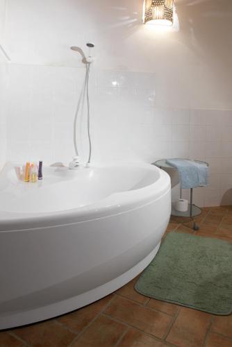 a white bath tub in a bathroom with a green rug at Antico casale per relax e natura in Casiano