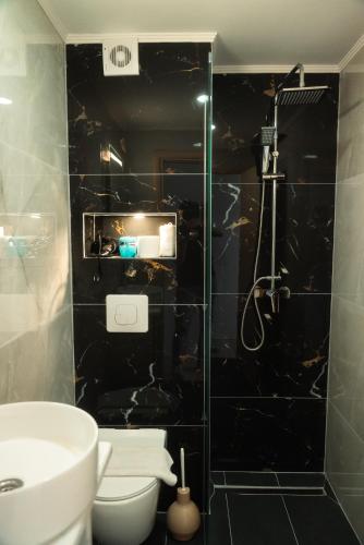 a bathroom with a shower with a toilet and a sink at Aktis Sea View Studios in Perea