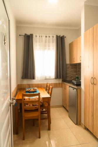 a small kitchen with a wooden table and a window at Aktis Sea View Studios in Perea
